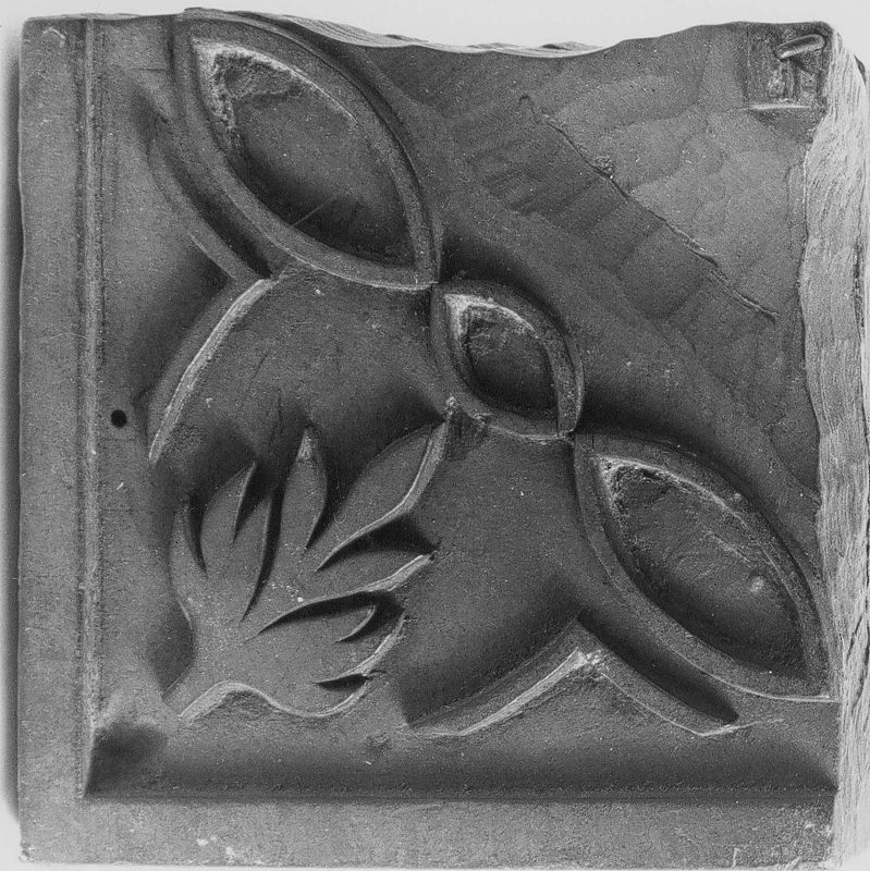 Drukzijde met een brede lijst, een palmetmotief en 2 golvende lijntjes in reliëf