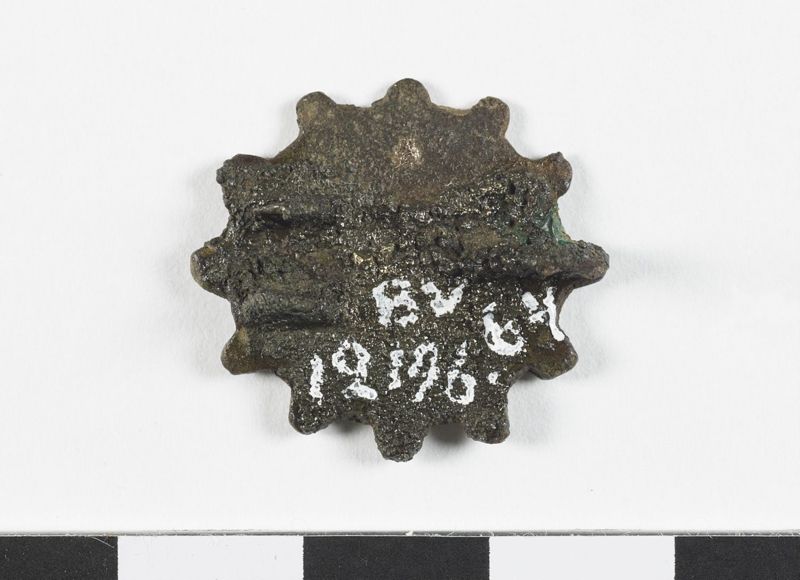 Fibule géométrique plate émaillée à charnière, en forme de cercle orné d'un motif en étoile et entouré de douze petites protubérances