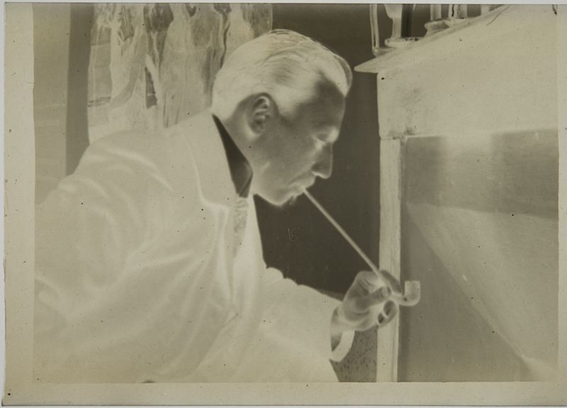 Henri Evenepoel à la pipe devant la cheminée dans l'atelier