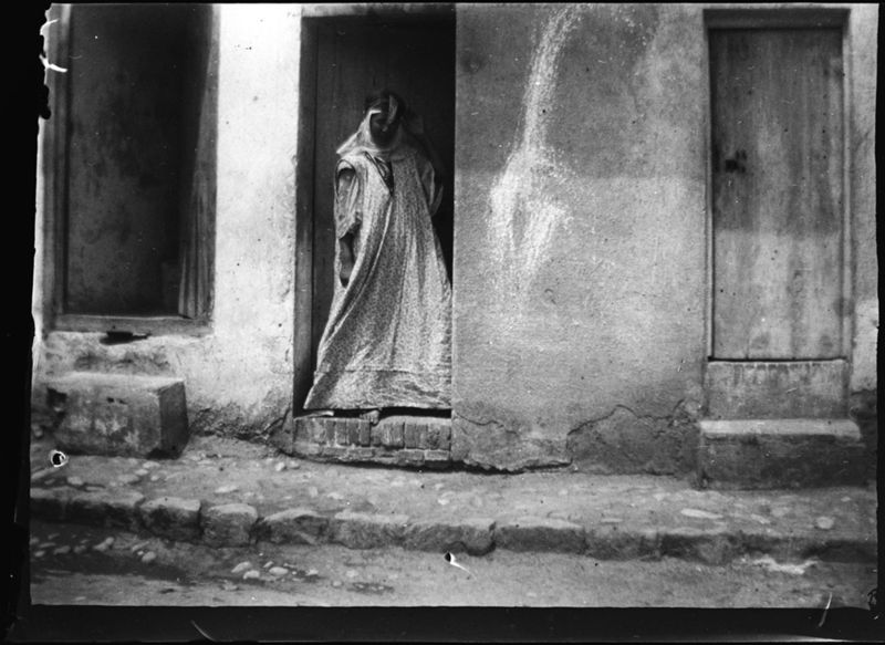 Scène de rue, femme à la porte de sa maison dans le quartier des Ouled Naïl(Biskra)