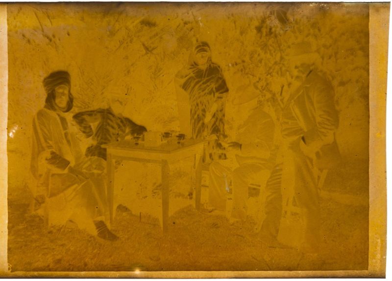 Edmond Evenepoel, Albert Noyer rédacteur en chef du "Progrès de Biskra", un serviteur, le Colonel Schneider et l'instituteur Mohammed ben El Hadji Okba déjeunant au jardin (Sidi Okba)