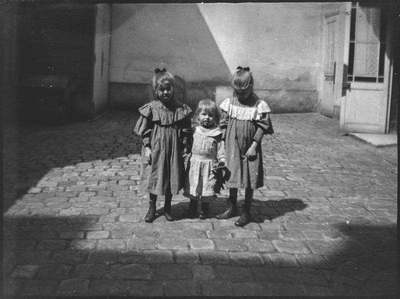Sophie, Charles et Henriette De Mey dans une cour d'immeuble (Paris ?).