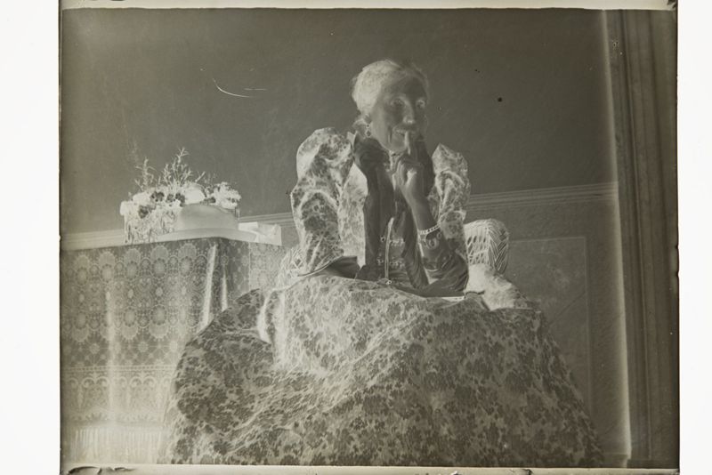 Sophie Fraikin-Devis assise dans un fauteuil en osier dans la maison du Trieu-Colin à Fooz-Wépion