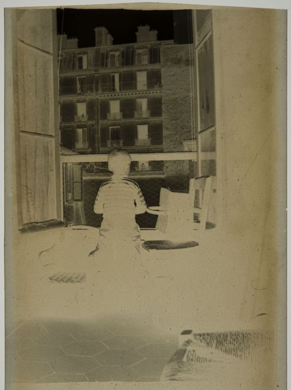 Charles De Mey au jersey rayé (de dos) devant  la fenêtre, rue Saint-Dominique à Paris