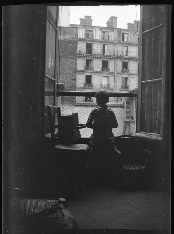 Charles De Mey au jersey rayé (de dos) devant  la fenêtre, rue Saint-Dominique à Paris