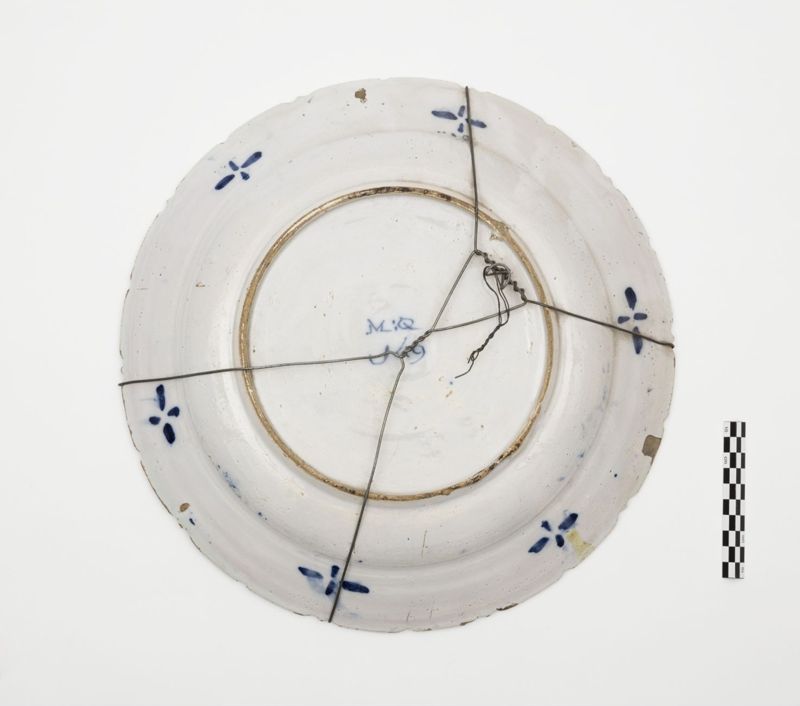 Plat en faïence de Delft au décor d'un vase de fleurs, de lambrequins et de jardinières fleuries