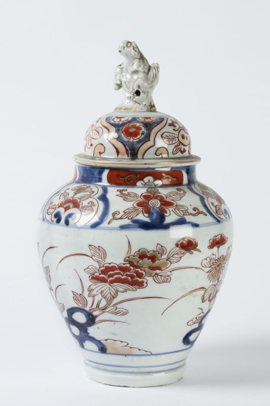 Potiche en porcelaine à décor de fleurs et au couvercle surmonté d'une figurine