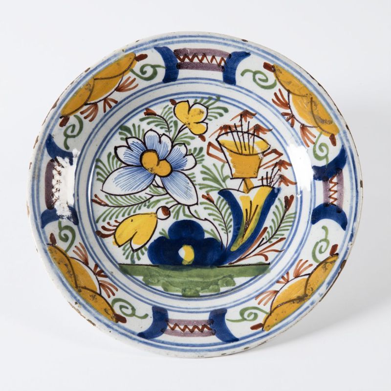 Assiette en faïence à décor de fleurs et de vase