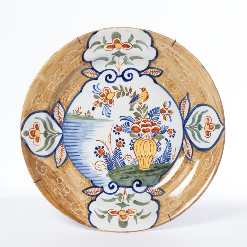 Plat en faïence de Delft au décor polychrome d’un vase fleuri et d’un oiseau