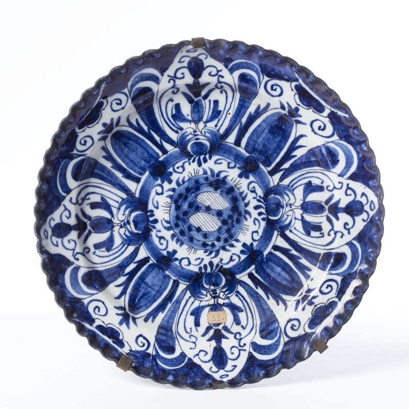 Plat festonné en faïence de Delft au décor de quatre réserves de fleurs