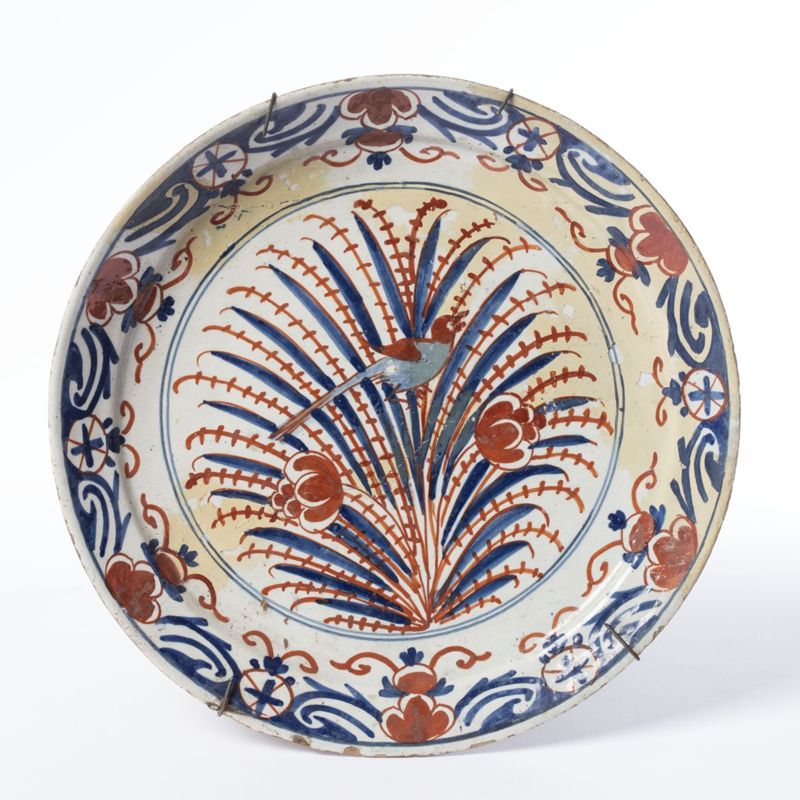 Assiette en faïence de Delft au décor de branches fleuries et d’un oiseau