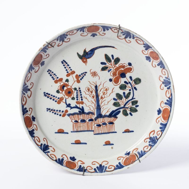 Assiette en faïence de Delft au décor polychrome de deux jardinières et d’un oiseau