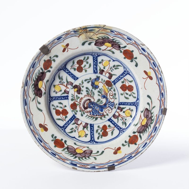 Assiette en faïence de Delft au décor polychrome de fleurs et de huit réserves de fruits