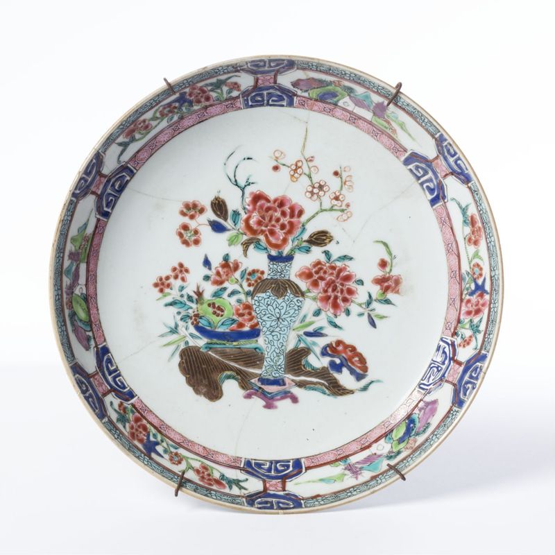 Assiette en porcelaine au décor polychrome de vase et de jardinière fleuris