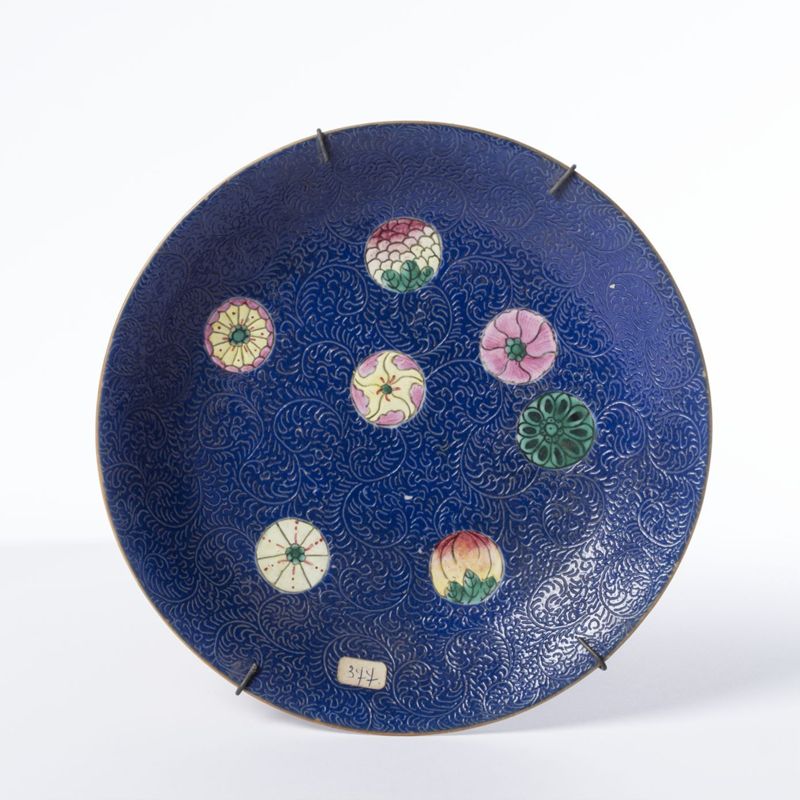 Assiette en porcelaine au décor polychrome de médaillons fleuris